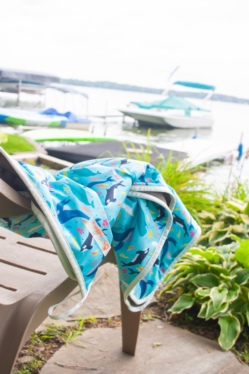 multi-purpose mat folded on top of a chair that is facing the lake