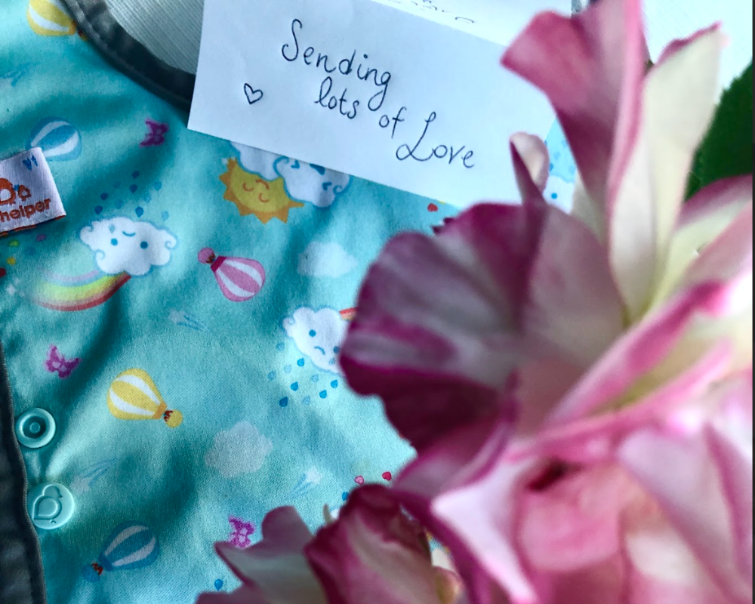 Floral arrangement with a card reading 'Sending lots of love' on a colorful background