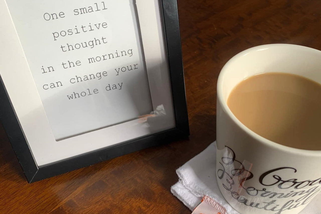 a cup of coffee sitting next to a picture frame
